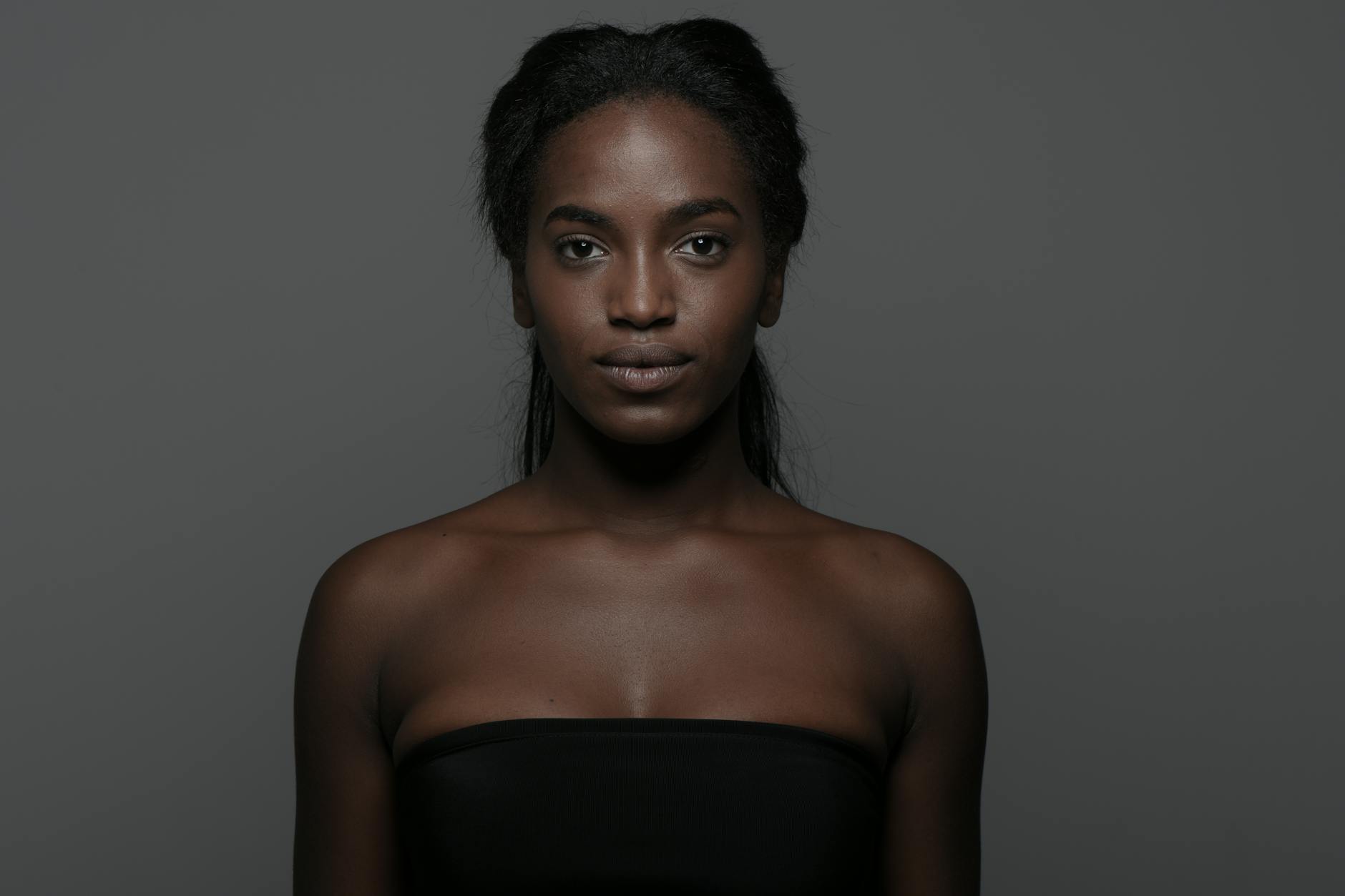 Beauty model with radiant glowing skin showcasing exfoliated face and body in natural makeup look for healthy skincare benefits.